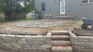 Natural stone wall and patio design and installed within a native landscape