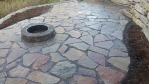 Design and installation of natural stone patio with firepit to enjoy a planted native landscape